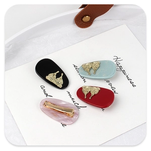 Detailed set of acetate oval hair clips with elegant gold butterfly accents in four colors