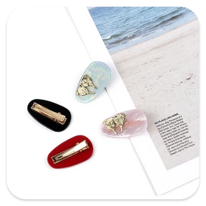 Macro detail of elegant acetate butterfly hair clips with gold metal inlay in four colors