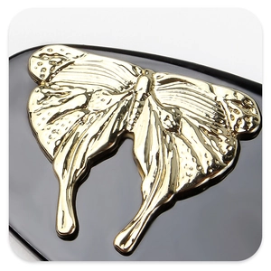 Macro shot of golden butterfly hair clip with relief texture on black acetate base