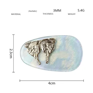 Detail view of acetate golden butterfly hair clip with dimensions 4cm x 2.3cm and 5.4g weight