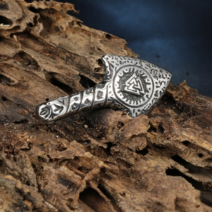 Macro detail of Nordic Viking Mjölnir pendant with Valknut symbol on rustic wood