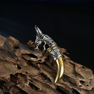 Makroaufnahme von Silber und Gold Wolfskopf Anhänger mit Gravuren auf dunklem Holz