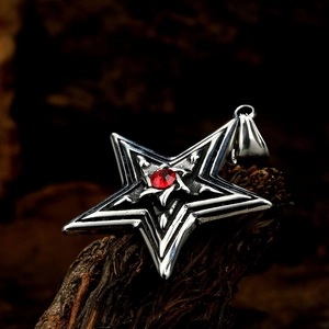 Detailed macro view of silver star pendant with red gemstone and gothic carving