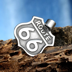 Détail du pendentif Route 66 en acier inoxydable vintage sur une écorce de bois texturée