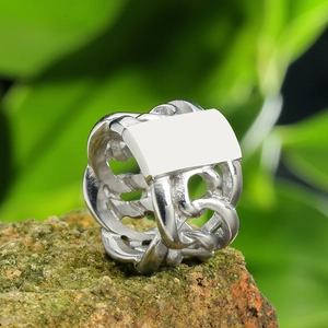 Men's heavy stainless steel chain ring with flat rectangular top on natural rock surface