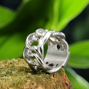 Detailed close-up of a masculine silver steel ring with chain link design on mossy stone
