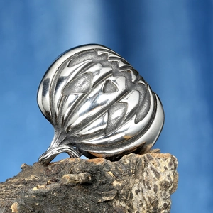 Detailed view of vintage silver pumpkin ring with intricate carvings on wooden texture
