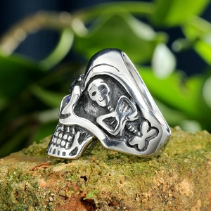 Close-up of vintage gothic skull ring with intricate skeletal carvings on weathered brick