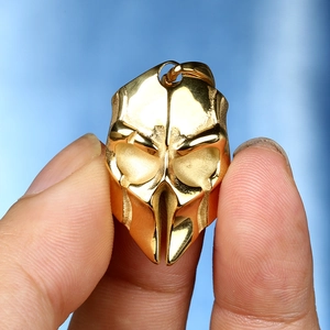 Close-up of golden skull warrior helmet pendant with high polished metallic finish