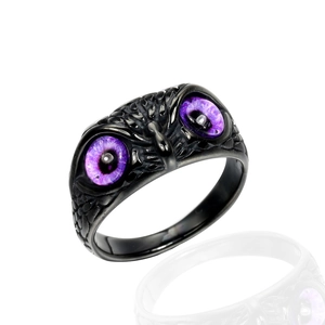 Dettaglio macro dell'anello gufo gotico con occhi di cristallo viola e piume nere