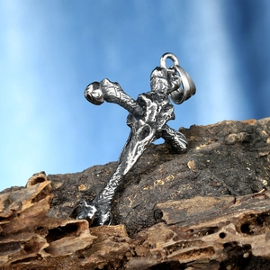 Détail du pendentif croix en acier avec texture d'os sur fond d'écorce boisée