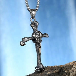 Détail macro d'un pendentif croix tête de mort gothique viking avec finition oxydée