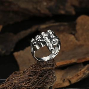 Vintage punk fist middle finger ring in silver stainless steel on wood bark