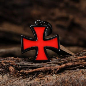 Vintage gothic red and black stainless steel cross pendant on dark wood background