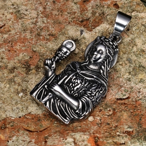 Vintage religious pendant in stainless steel with crystal detail on stone background