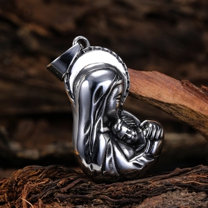 Pendentif Vierge à l'Enfant en acier inoxydable vintage sur fond de bois sombre texturé