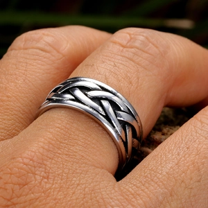 Gros plan de la bague viking tressée en acier inoxydable avec texture vintage oxydée