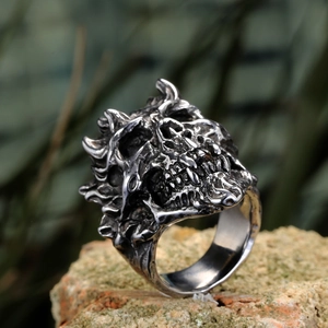 Gothic skull ring made of vintage steel displayed on a rugged natural rock background