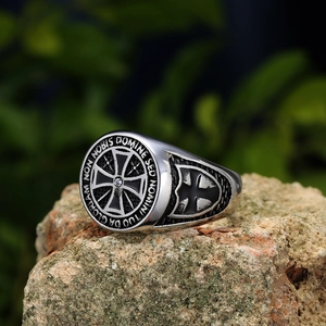 Dettaglio macro dell'anello dei Templari in acciaio con incisione latina su roccia