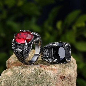 Gothic dragon claw rings with red and black oval stones on natural rock base