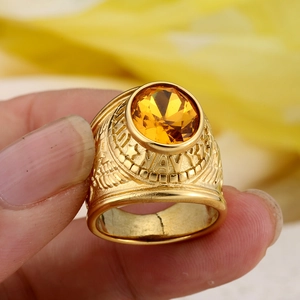 Golden US Navy military ring featuring an oval yellow gemstone and eagle relief