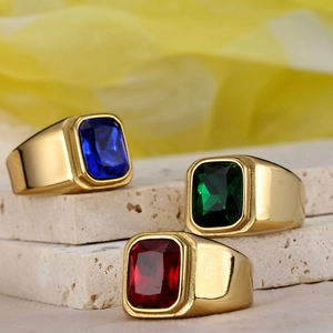 Vintage signet rings in gold finish with blue, green and red gemstones on stone stand