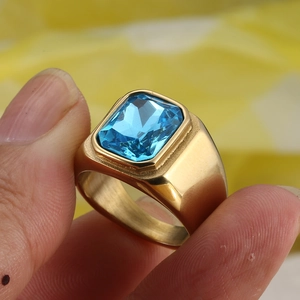 Detail view of a men's vintage gold titanium ring featuring a large blue rectangle sapphire