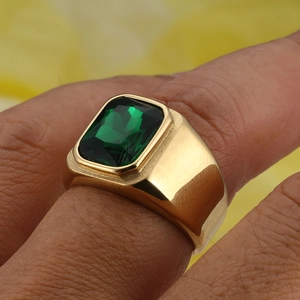 Macro shot of a vintage gold titanium ring featuring a large rectangular green gemstone