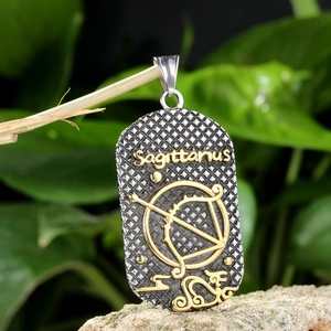 Detalle del colgante Sagitario con símbolo dorado en placa de acero texturizada