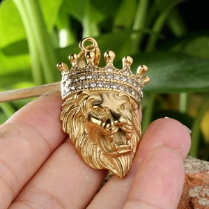 Detailed view of a gold lion head pendant with sparkling rhinestones and crown
