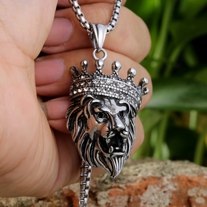 Macro shot of silver hip hop lion head pendant with iced-out crown and box chain