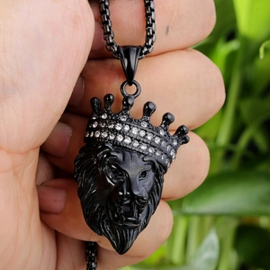 Macro shot of matte black hip hop lion head pendant with iced-out crown detailing