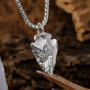 Détail d'un pendentif flèche vintage avec texture rustique sur fond de bois naturel