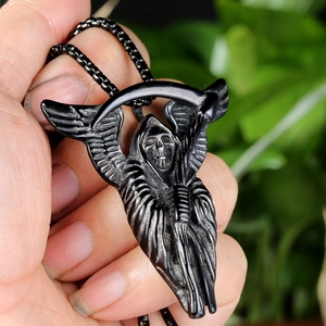 Detail of a matte black Grim Reaper scythe pendant with wings and a ball chain necklace