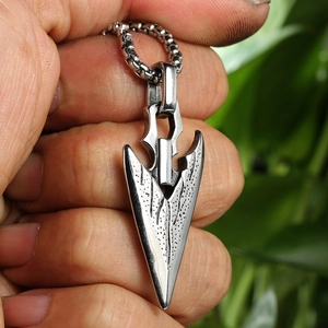 Macro shot of men's stainless steel arrowhead pendant with vintage textured patterns