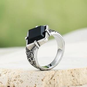 Close-up of vintage titanium steel ring with black square gemstone and lava texture