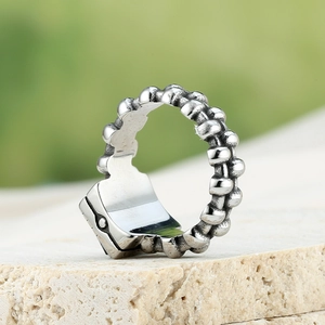 Macro-opname van een industriële zilveren ring met kettingtextuur en geheim vakje