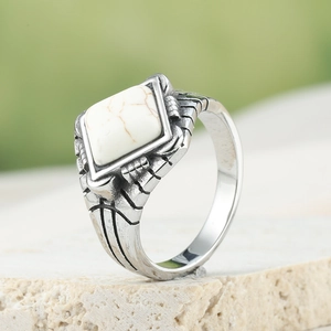 Vintage men's titanium steel ring with a square white marble stone on a stone base