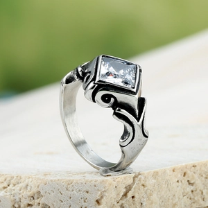 Bague vintage argentée avec zircon carré et motifs en relief sur fond de pierre