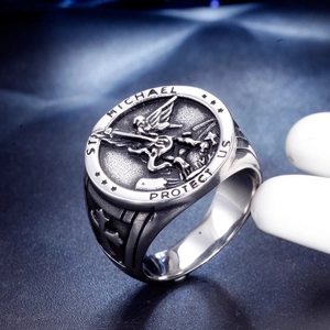 Macro detail of St Michael religious relief and cross symbol on stainless steel ring