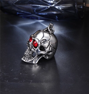 Macro detail of punk skull pendant featuring red zircon eyes and vintage steel texture