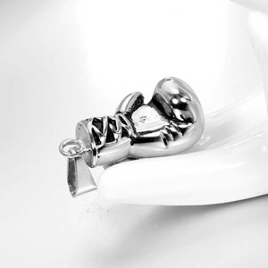Macro detail of a silver boxing glove pendant with realistic lacing and stitching textures