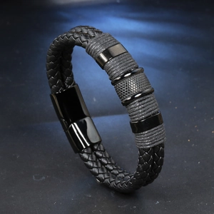 Detail of men's braided black leather bracelet with textured black stainless steel magnetic clasp