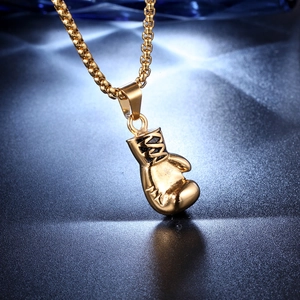 Macro shot of gold boxing glove pendant necklace with polished finish and box chain