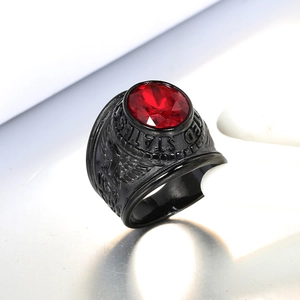 Macro shot of men's black military ring with red oval gemstone and US eagle relief details