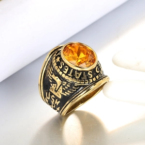 Macro shot of gold-plated army ring with orange gemstone and detailed eagle relief