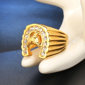 Detail van gouden paardenhoofdring met fonkelende steentjes en gegroefde textuurband