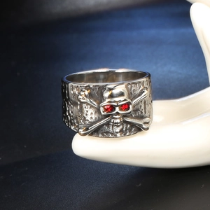 Anello teschio punk in acciaio al titanio con occhi in zircone rosso su mano