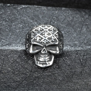Close-up of vintage stainless steel skull ring with intricate fleur-de-lis engraved details