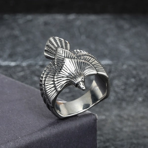 Retro eagle stainless steel ring with intricate feather texture on grey stone background